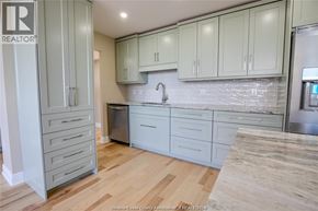 Windsor condo for rent - A kitchen with wooden floors and white cabinets.
