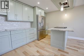 Windsor condo for rent - A kitchen with white cabinets and a wooden floor.