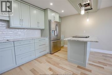 Windsor condo for rent - A kitchen with white cabinets and a wooden floor.