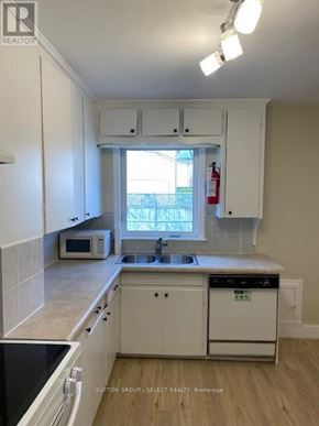 London North (North K) triplex for rent - A kitchen with white cabinets and a black counter top.