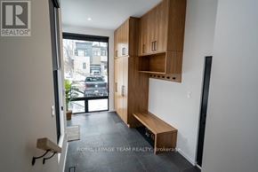 Ottawa apartment for rent - A room with a wooden bench and cabinets with a sign that says "Royal LePage Team Realty Brokerage".