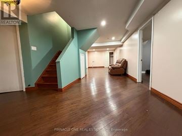 Toronto (Morningside) apartment for rent - A living room with a brown sofa and a staircase.