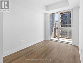 Vaughan (Beverley Glen) condo for rent - A room with a view of a cityscape through a glass door.