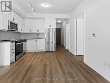Vaughan (Beverley Glen) condo for rent - A kitchen with white cabinets and a wooden floor.