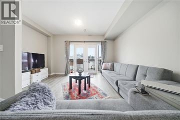 Brantford townhouse for rent - A living room with a grey couch and a red rug.