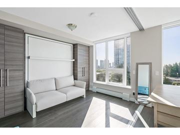 Surrey apartment for rent - A modern living room with a white sofa and a large window.