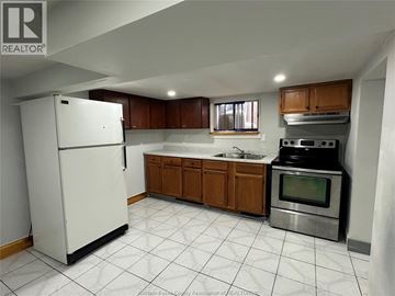 Windsor apartment for rent - A kitchen with white appliances and wooden cabinets.