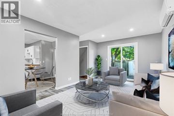 Windsor apartment for rent - A living room with a grey couch and a glass coffee table.