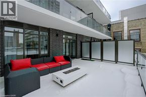 Kitchener condo for rent - A bedroom with a bed, nightstand, and window.
