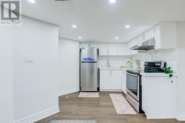 Toronto (Rouge) apartment for rent - A kitchen with white cabinets and a stainless steel refrigerator.