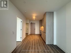 Vaughan (Vaughan Corporate Centre) condo for rent - A hallway with wood flooring and white walls.