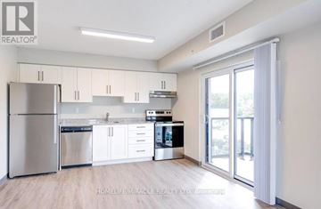 Kitchener multi-family for rent - A modern kitchen with white cabinets and stainless steel appliances.