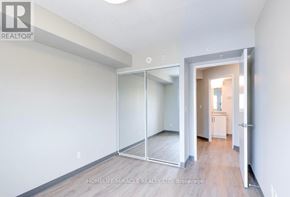 Kitchener multi-family for rent - A room with a white wall and a wooden floor.