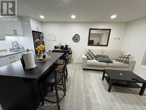 Vaughan (Maple) duplex for rent - A modern kitchen with a black countertop and a dining area with a couch.