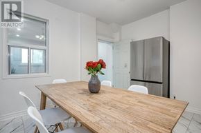 Toronto (South Riverdale) apartment for rent - A dining room with a wooden table and white chairs.
