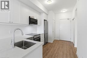Bowmanville condo for rent - A kitchen with white cabinets and a stainless steel sink.