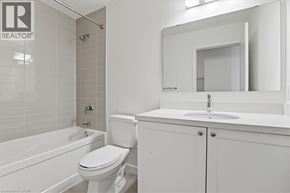 Bowmanville condo for rent - A white bathroom with a toilet, sink, and bathtub.