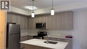 Kitchener townhouse for rent - A kitchen with a refrigerator, microwave, and sink.