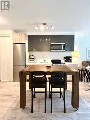 Toronto (Downsview-Roding-Cfb) condo for rent - A modern kitchen with a wooden table and chairs.