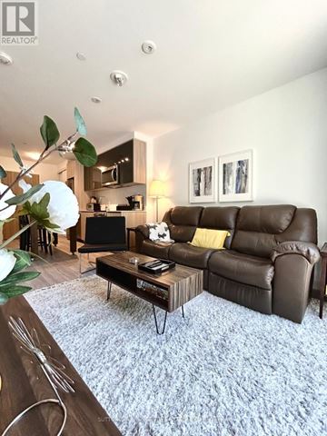 Toronto (Downsview-Roding-Cfb) condo for rent - A living room with a brown leather couch and a coffee table.