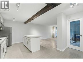 North Vancouver apartment for rent - A spacious kitchen with white cabinets and a wooden ceiling beam.