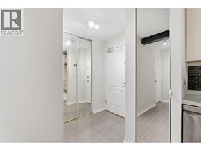 North Vancouver apartment for rent - A white hallway with a mirrored door and a Realtor logo.