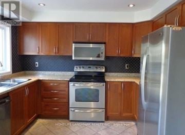 Brampton (Fletcher's Meadow) apartment for rent - A kitchen with wooden cabinets and a stainless steel refrigerator.