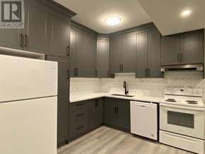 Fort Erie (Central) apartment for rent - A kitchen with a white fridge and a white dishwasher.