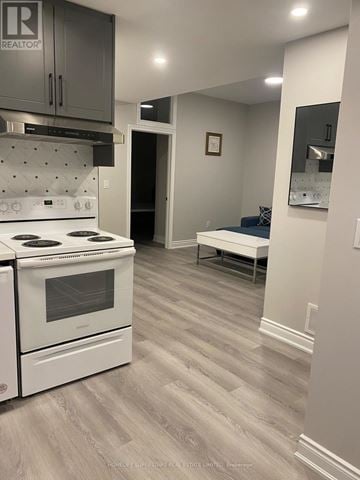 Fort Erie (Central) apartment for rent - A kitchen with a white stove and grey cabinets.
