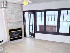 Fort Erie apartment for rent - A room with a fireplace and a ceiling fan.