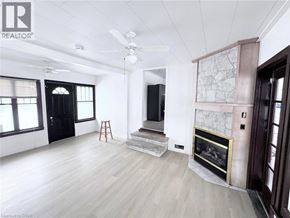 Fort Erie apartment for rent - A spacious living room with a fireplace and a bar stool.