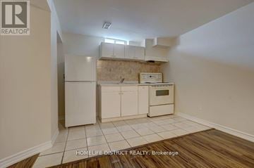 Pickering (Village East) apartment for rent - A kitchen with white cabinets and a wooden floor.