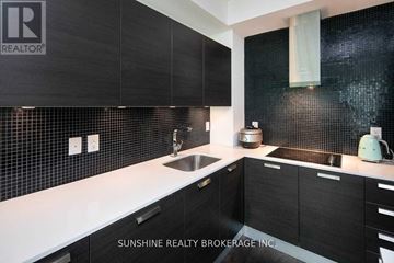 Toronto (Lansing-Westgate) condo for rent - A modern kitchen with black cabinets and a white countertop.