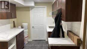 Kitchener apartment for rent - A white door is in the middle of a room with brown cabinets.