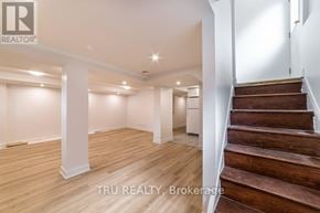 Ottawa apartment for rent - A spacious room with wooden floors and a staircase leading to another level.