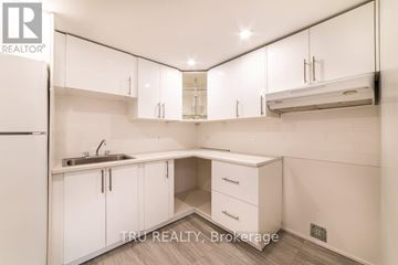 Ottawa apartment for rent - A white kitchen with a sink and cabinets.