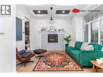 Vancouver apartment for rent - A living room with a green couch and a fireplace.