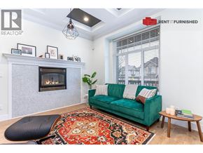 Vancouver apartment for rent - A living room with a green couch and a fireplace.