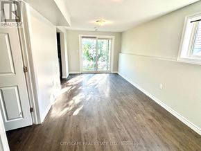 Barrie (Holly) apartment for rent - A room with wooden flooring and a sliding glass door leading outside.