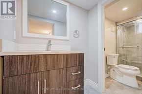 Toronto (Kensington-Chinatown) apartment for rent - A bathroom with a white toilet and a wooden cabinet.