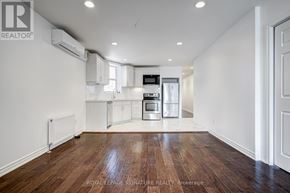 Toronto (Little Portugal) townhouse for rent - A spacious kitchen with white cabinets and a wooden floor.