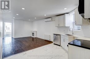 Toronto (Little Portugal) townhouse for rent - A kitchen with white cabinets and a black countertop.
