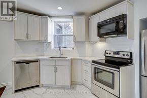 Toronto (Little Portugal) townhouse for rent - A kitchen with white cabinets and appliances.