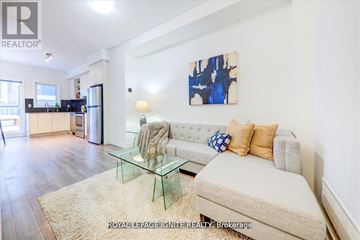 Toronto (Downsview-Roding-Cfb) townhouse for rent - A living room with a couch, a glass table, and a painting on the wall.