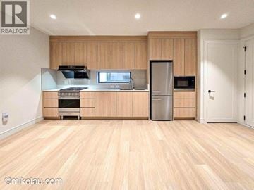 Vancouver apartment for rent - A kitchen with wooden cabinets and a refrigerator.