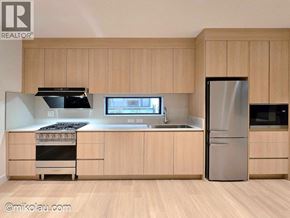 Vancouver apartment for rent - A modern kitchen with wooden cabinets and stainless steel appliances.