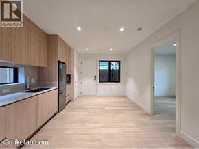 Vancouver apartment for rent - A spacious kitchen with wooden cabinets and a large island.