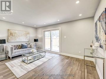 Mississauga (Cooksville) apartment for rent - A spacious living room with a glass coffee table and a large painting on the wall.
