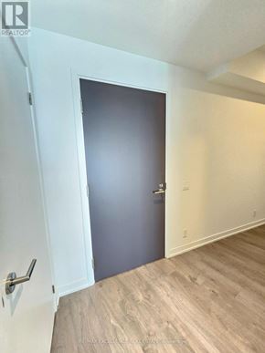 Barrie (City Centre) condo for rent - A room with a wooden floor and a closed door.