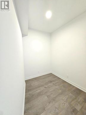 Barrie (City Centre) condo for rent - A room with a wooden floor and white walls.
